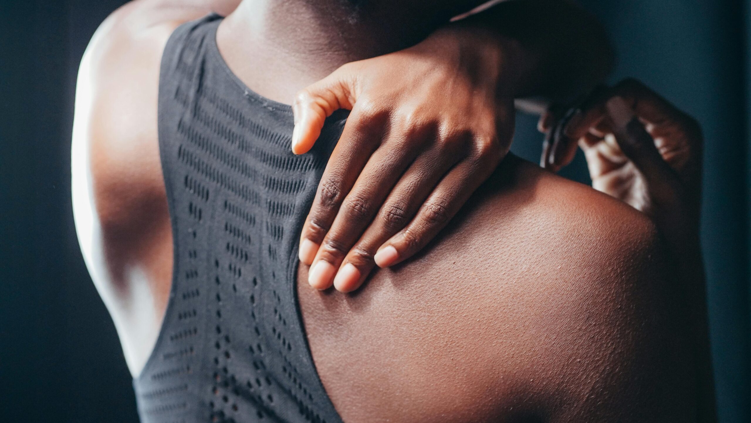 Person holding mid back showing upper and mid back pain symptoms can be treated with chiropractic care at our Power Ranch clinic in Queen Creek, AZ