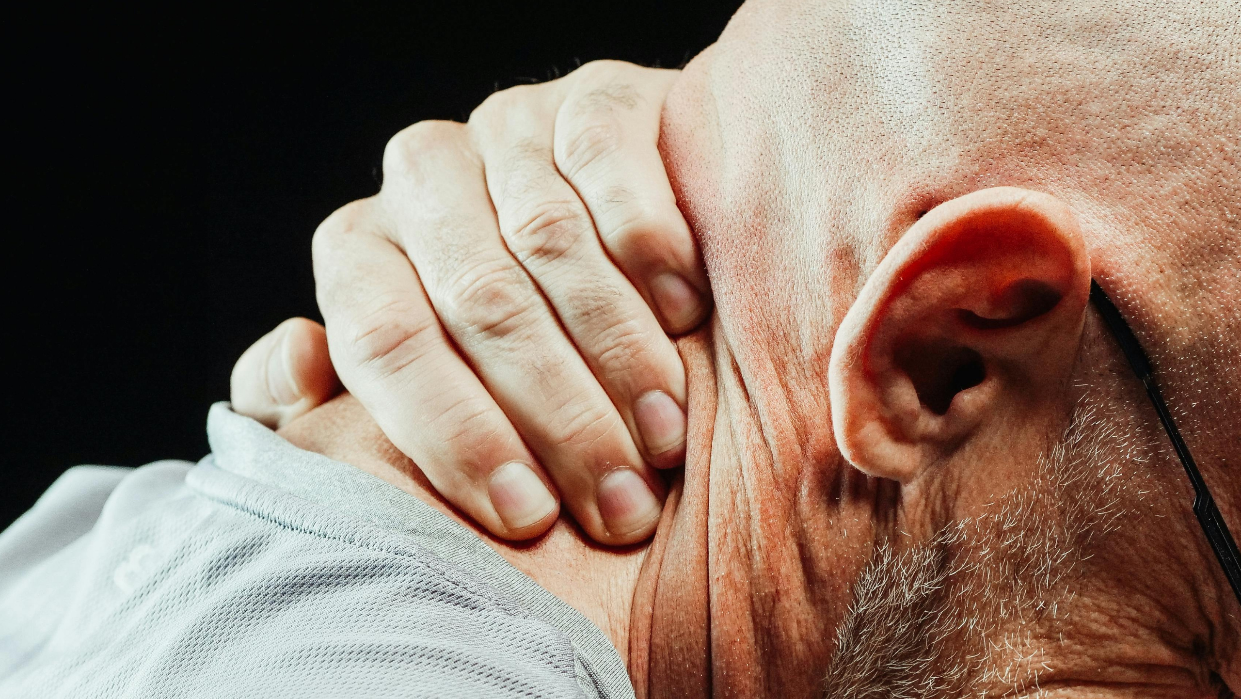 man with neck pain seeking chiropractic care in San Tan Valley AZ