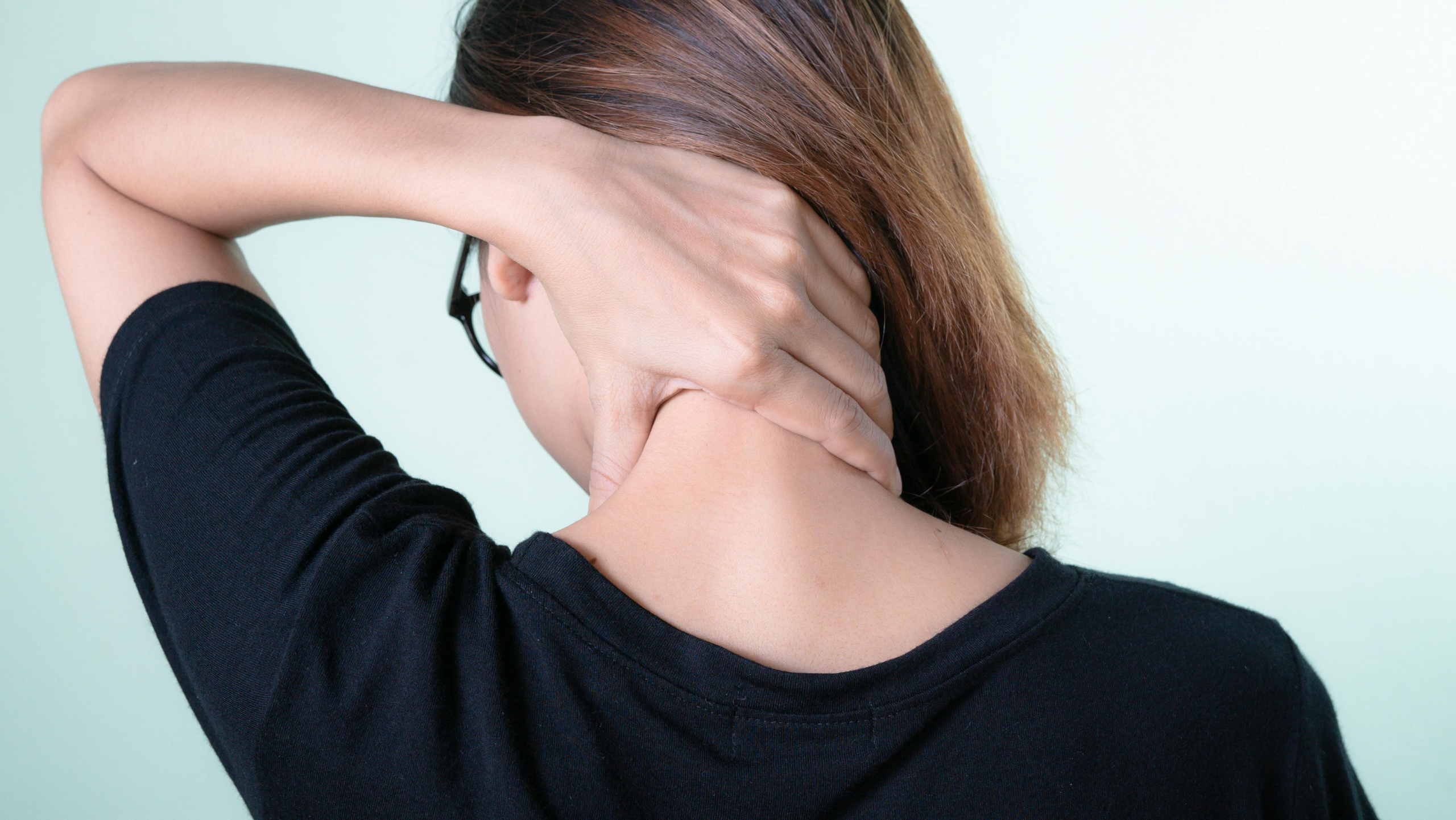 Woman holding neck with pain seeking chiropractic treatment in Queen Creek, AZ