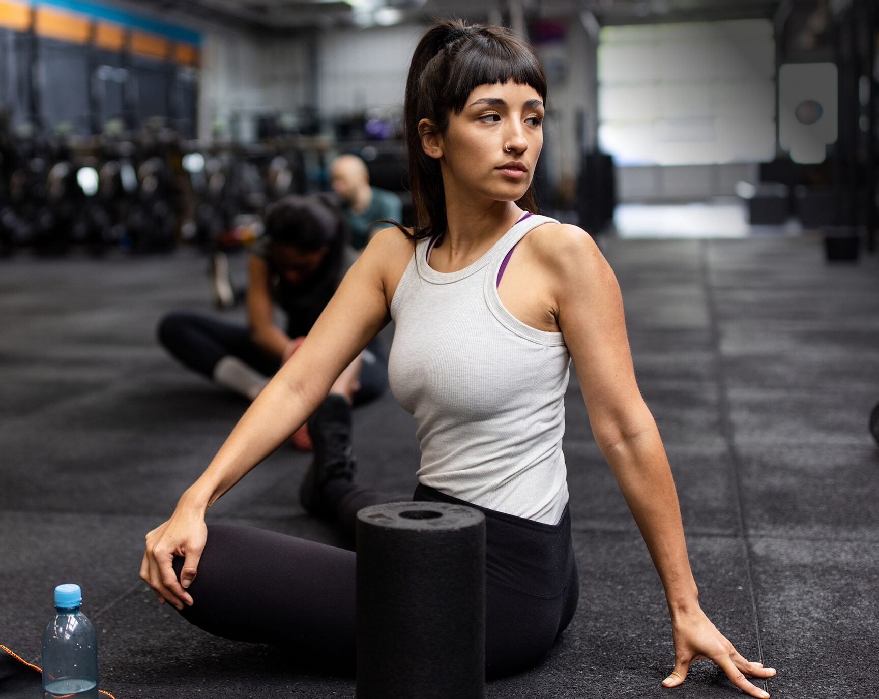 active-woman-exercising-with-low-back-pain Active woman stretching in a gym, representing physically active adults managing low back pain.