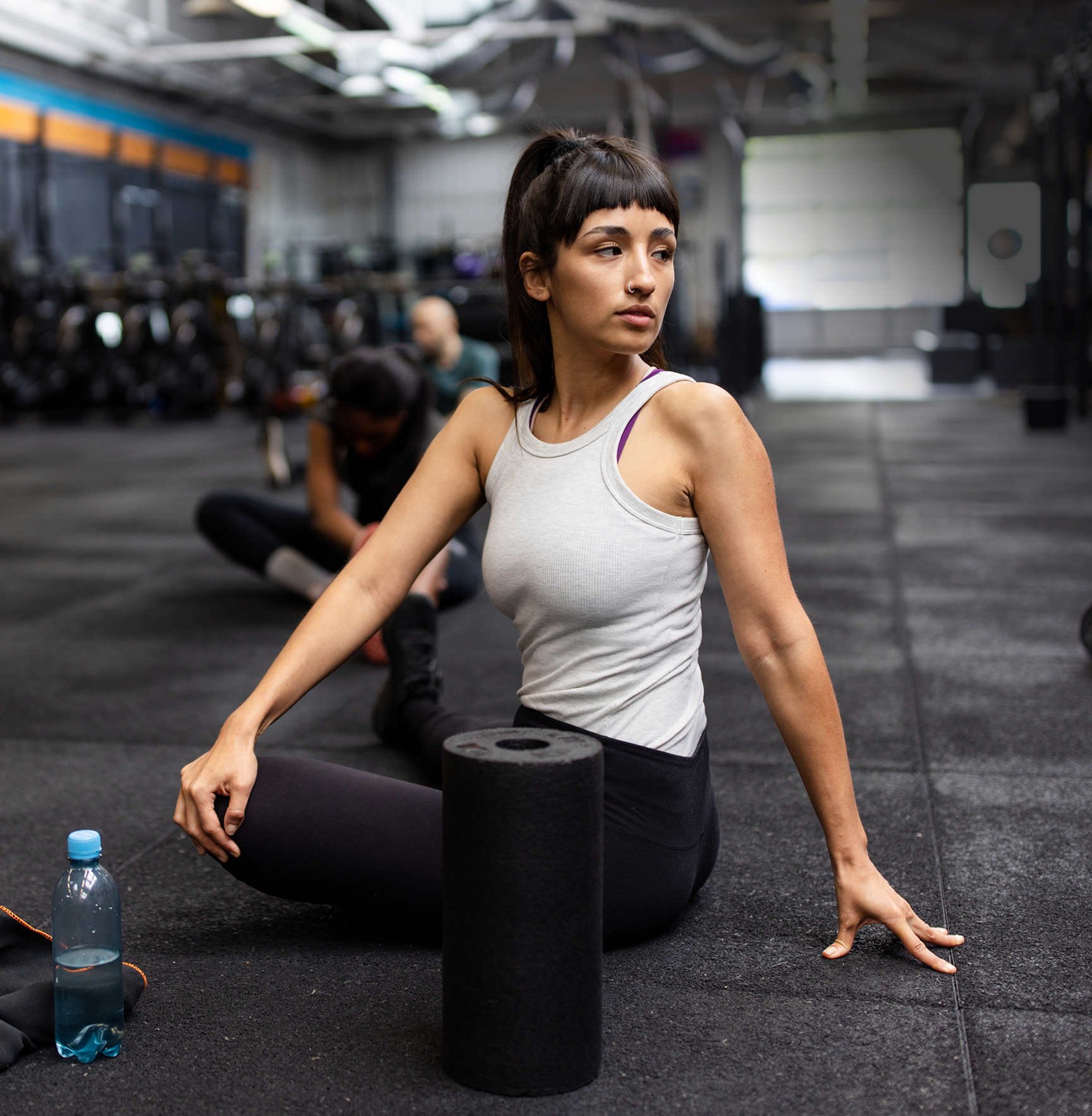 Active woman stretching in a gym, representing physically active adults managing low back pain.