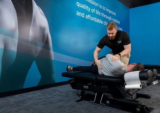 The Joint Chiropractor in Southeast Valley performing a lower back adjustment on a patient for sciatica during a chiropractic visit.