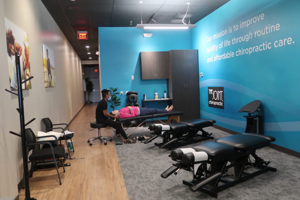Interior of The Joint Chiropractic clinic in the Southeast Valley featuring chiropractic adjustment tables and a welcoming treatment area.