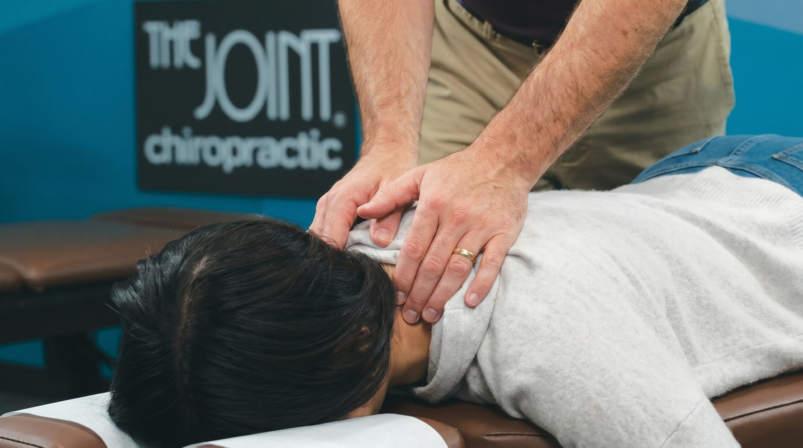 the-joint-chiropractic-neck-adjustment-headaches-southeast-valley-az Chiropractor performing a gentle cervical spine adjustment on a patient to help relieve neck pain and headaches.
