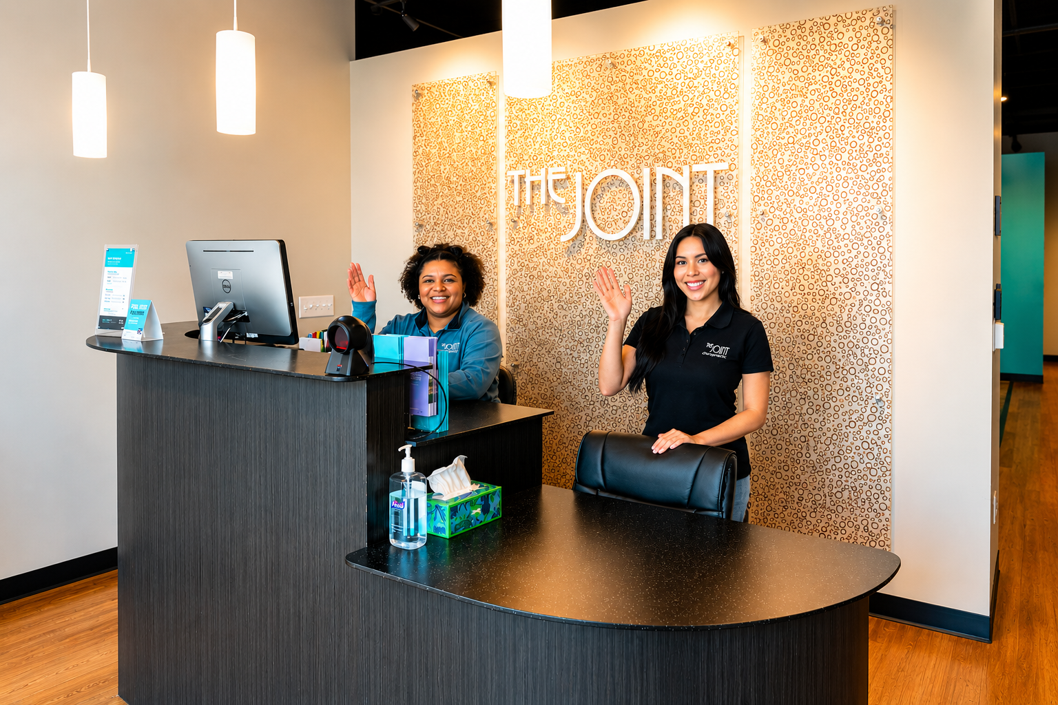 the-joint-chiropractic-southeast-valley-reception-desk Two team members greeting patients at the front desk of The Joint Chiropractic clinic in the Southeast Valley.