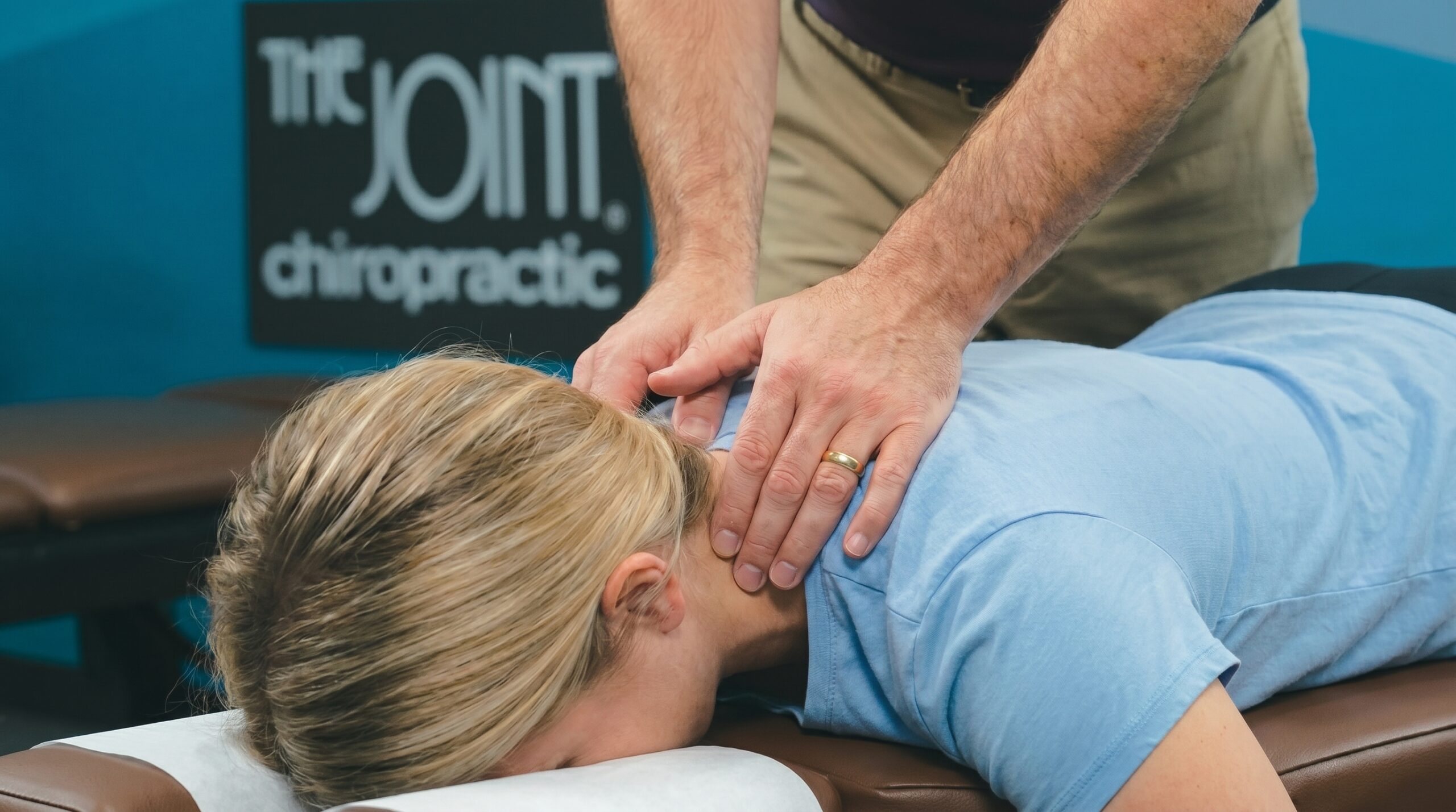 The Joint chiropractor  in Southeast Valley performing a neck adjustment on a patient.