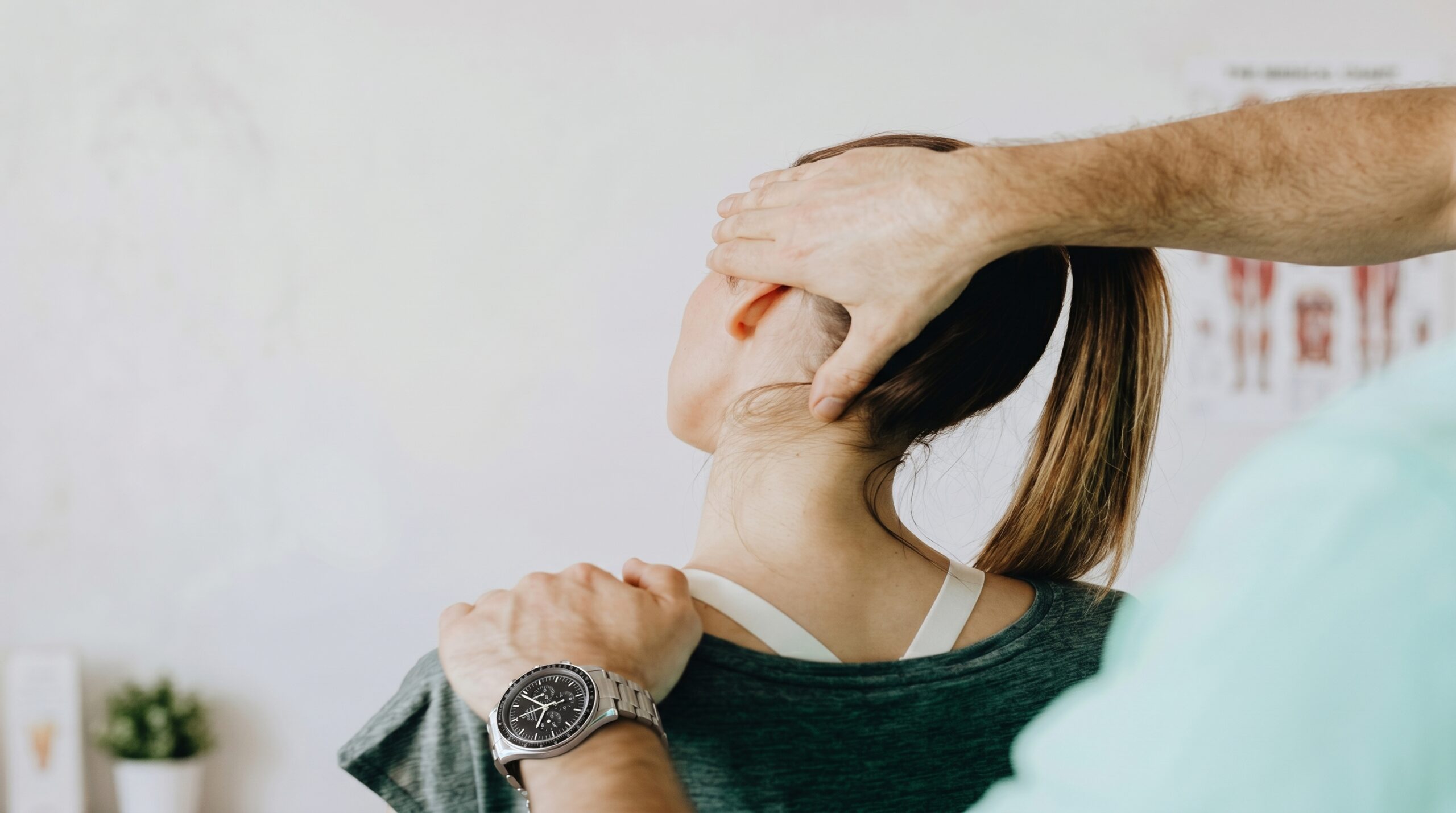Chiropractor performing a spinal adjustment on a seated patient
